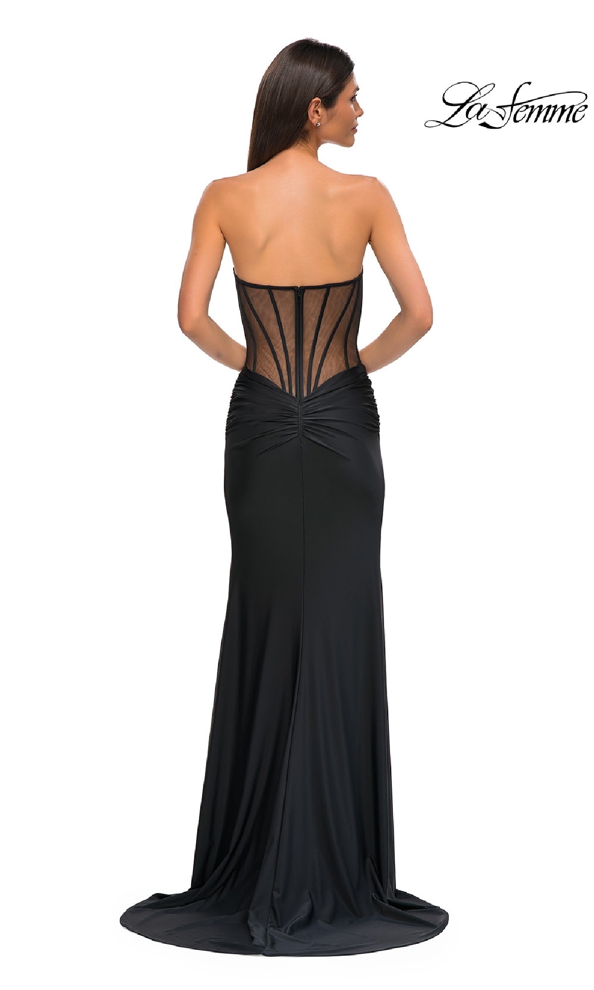 Woman wearing the Sheer-Waist Long Corset Prom Dress (La Femme 32912) with a strapless neckline, ruched detailing, beaded lace accents, and a sheer structured back, standing with her back to the camera.