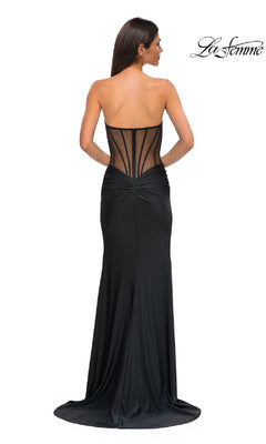 Woman wearing the Sheer-Waist Long Corset Prom Dress (La Femme 32912) with a strapless neckline, ruched detailing, beaded lace accents, and a sheer structured back, standing with her back to the camera.