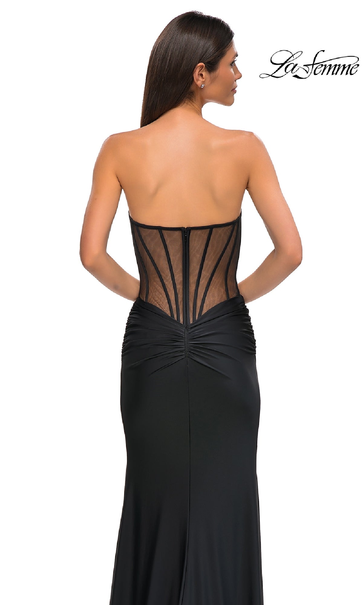 A woman wears the Sheer-Waist Long Corset Prom Dress: La Femme 32912, featuring a strapless design, sheer corset-style back with visible boning, and elegant beaded lace details. The La Femme logo appears in the top right on a white background.