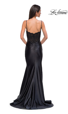 A woman models the Black Mermaid Prom Dress: La Femme 32916, featuring an illusion lace bodice and spaghetti straps, seen from the back with the "La Femme" logo in the top right corner.