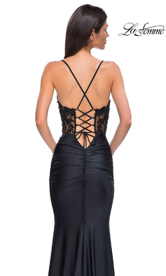 A woman wears the La Femme 32920 beaded-bodice long prom dress featuring a black, floor-length design with lace-up back, thin straps, and beaded corset detail; "La Femme" logo appears in the upper right corner.