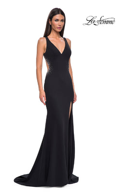 A woman models the Long Prom Dress: La Femme 32922— a sleeveless black jersey gown with a thigh-high slit and side embellishments—standing against a white background with the "La Femme" logo.