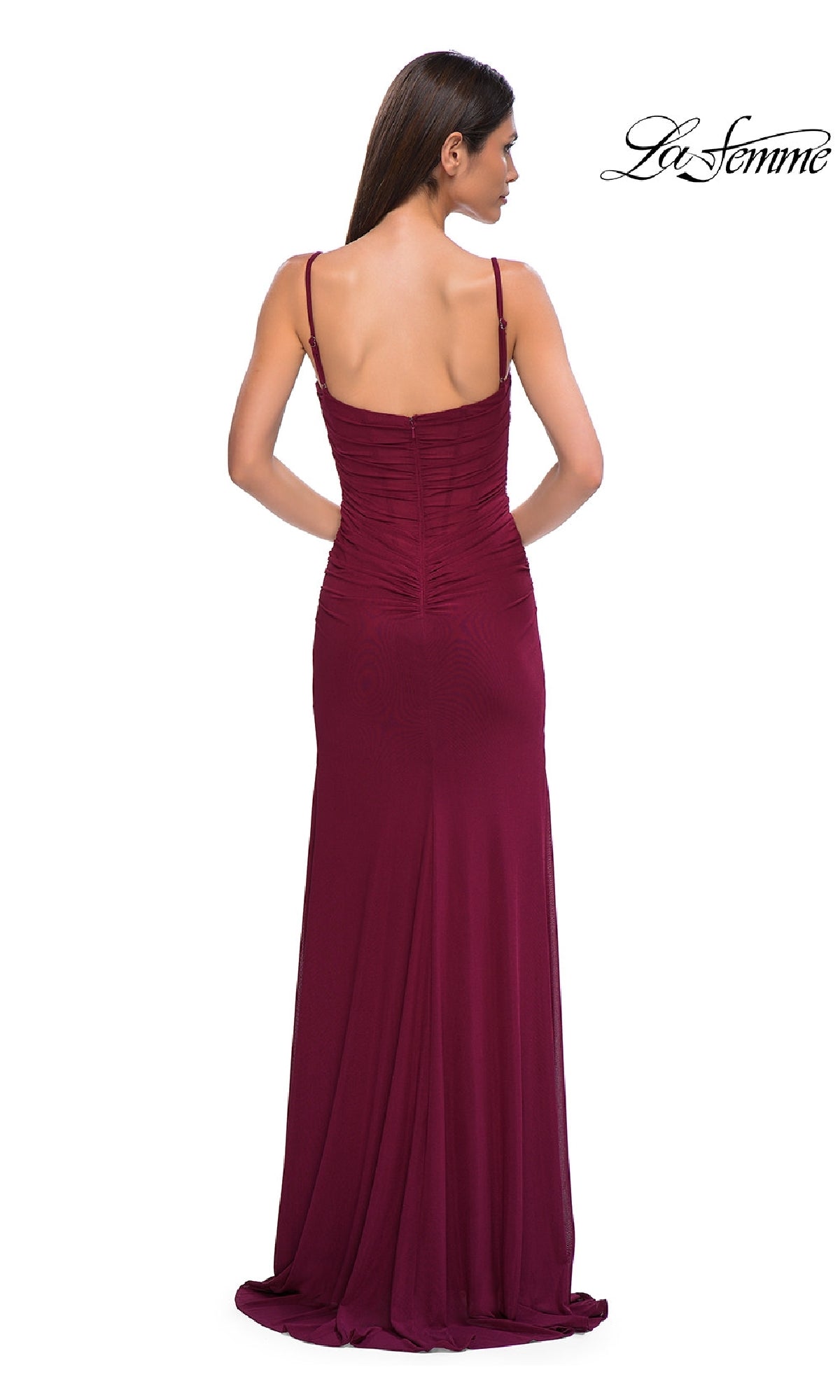 A woman faces away from the camera in the Classic Long Sweetheart Prom Dress: La Femme 32925—a floor-length, sleeveless dark red gown with thin straps, ruched detailing, a slight train, and a hint of corset-style bodice for elegance.