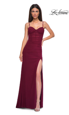 A woman wears the Classic Long Sweetheart Prom Dress: La Femme 32925, a fitted, sleeveless burgundy gown with spaghetti straps, corset-style bodice, and high thigh slit, standing against a plain white background.