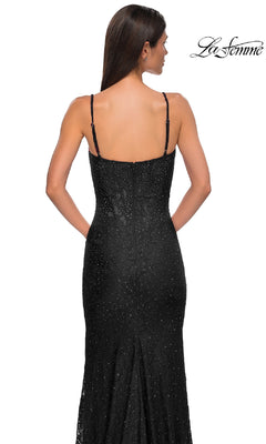 A woman with straight brown hair models the La Femme 32933 Long Beaded-Lace Prom Dress, a sleeveless black floor-length gown. Shown from the back on a white background, the La Femme logo appears in the top right corner.