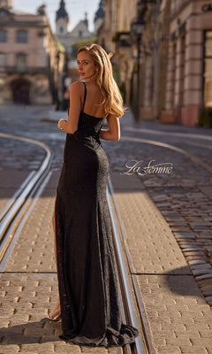 A woman wearing the Long Beaded-Lace Prom Dress (La Femme 32933) stands on a cobblestone street with tram tracks, glancing over her shoulder.