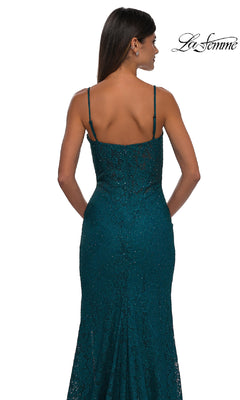 A woman, seen from the back, wears the Long Beaded-Lace Prom Dress (La Femme 32933) featuring teal beaded lace, thin straps, and subtle embellishments against a white background. The La Femme logo is in the top right corner.