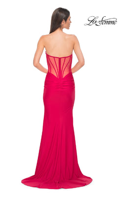 A woman models the La Femme 32941 Strapless Deep V-Neck Prom Gown—floor-length, fitted with a sheer corset-style back—against a white background. The "La Femme" logo appears in the upper right corner.