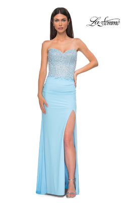 A woman models the Strapless Sweetheart Prom Gown: La Femme 32961—featuring a beaded corset bodice and thigh-high slit—while standing against a plain white background.