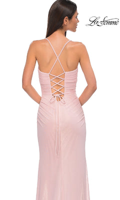 A woman faces away wearing the La Femme 32964 long prom dress, a light pink sleeveless gown with a crisscross lace-up back and thigh-high slit. The "La Femme" logo appears in the top right corner.
