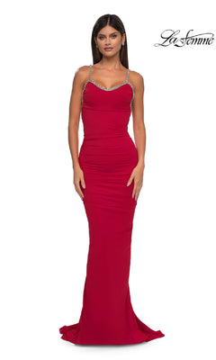 A woman in a fitted, floor-length red Backless Ruched Long Prom Dress: La Femme 32970 with thin jeweled straps stands against a white background, with the La Femme logo in the top right corner.