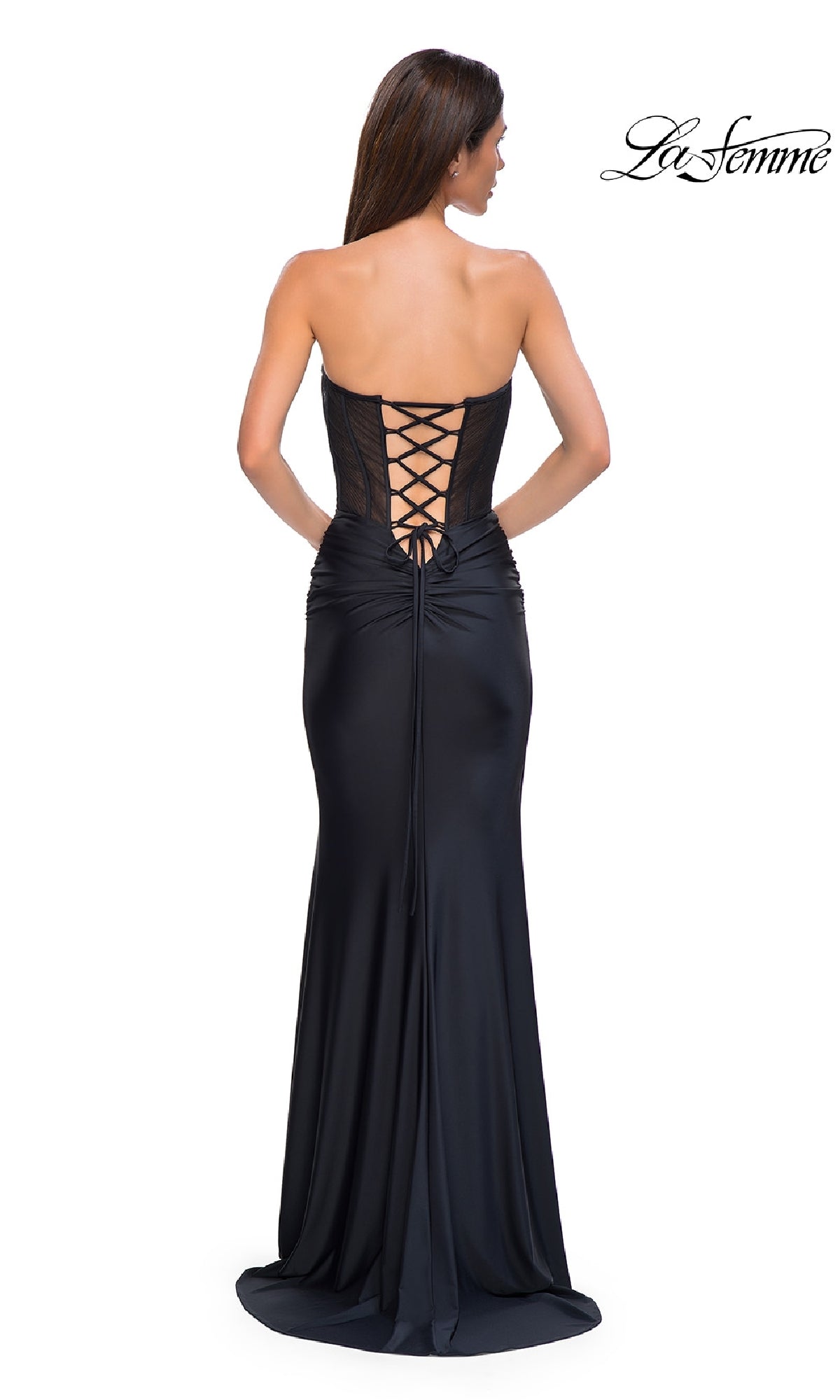 A woman stands with her back to the camera wearing the Strapless Long Corset Prom Dress: La Femme 32971. The fitted gown features lace-up back detailing and an elegant silhouette through the waist and hips.