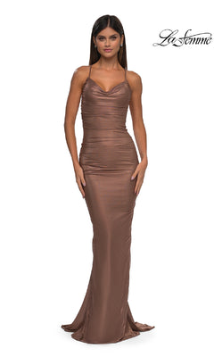 A woman models the La Femme 32973 Backless Metallic Jersey Prom Dress, featuring a fitted, metallic brown bodycon style with thin straps, against a white background. The La Femme logo appears in the top right corner.