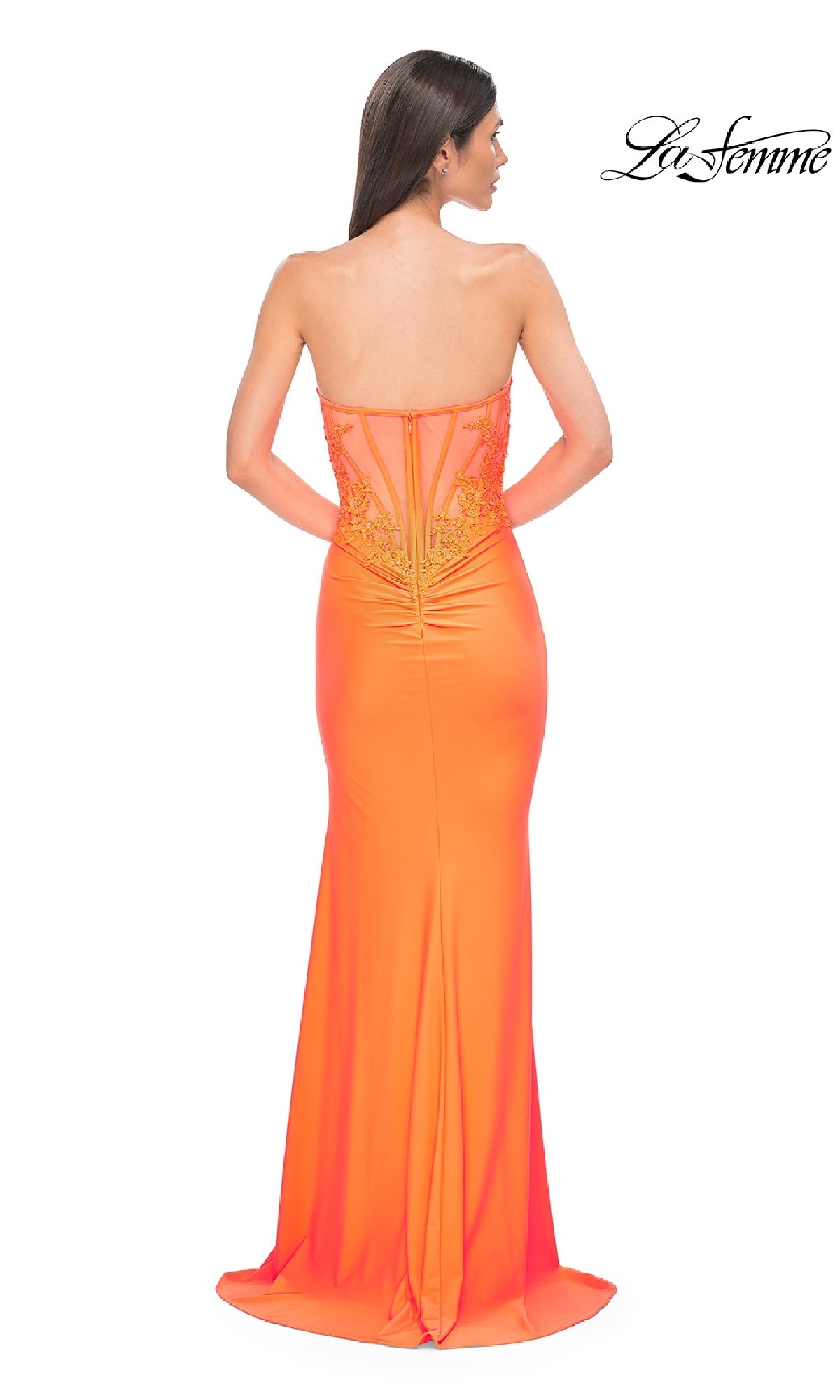 A woman models the La Femme 32981 beaded-bodice long prom dress in bright orange, shown from behind with beaded details and back embroidery. The 
