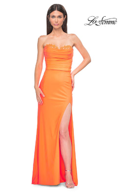 A woman models the La Femme 32981 beaded-bodice long prom dress in bright orange, featuring a strapless, floor-length design with a thigh-high slit and gold lace trim, set against a white background. La Femme logo is at the top right.