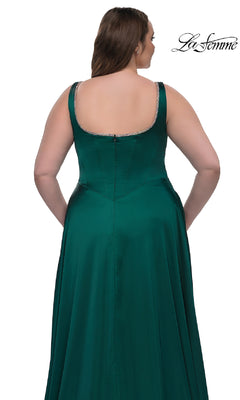A woman is seen from the back wearing the Plus-Size Classic Long Prom Gown La Femme 33026, a sleeveless emerald green satin dress with a zipper and crystal-trimmed neckline. The white background displays the La Femme logo.