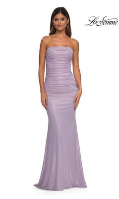 A woman modeling the Strapless Long Tube Prom Dress: La Femme 33033, featuring a metallic finish and ruched corset-style bodice, stands against a plain white background.