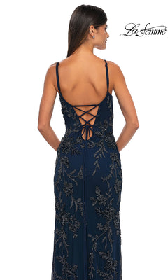 A woman stands facing away in the La Femme 33054 Lace-Up Long Beaded Prom Dress, featuring thin straps and a lace-up back.