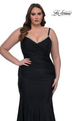 A woman poses against a white background in the La Femme 33057 plus-size floor-length prom dress, a fitted black gown with thin straps, a slight v-neckline, and subtle rhinestone accents. The "La Femme" logo is displayed.