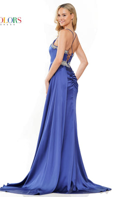 A woman poses against a white background wearing the Colors Dress Side-Drape Long Prom Dress 3305, featuring a floor-length royal blue design with a corset-style bodice, rhinestone accents, and a strappy open back.