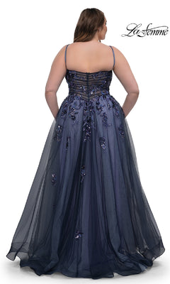 A woman showcases the La Femme 33061 navy plus-size prom dress from the back, featuring thin straps, sequin beaded floral appliqué, and a sheer overlay.