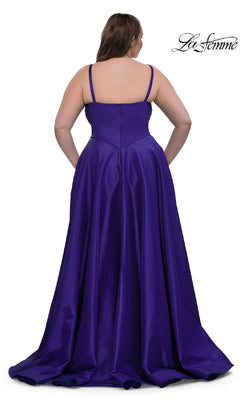 A woman is shown from the back wearing the La Femme 33075, a long plus-size prom dress. The gown features a shiny purple fabric, thin straps, sleeveless bodice, and a full, flowing a-line skirt.
