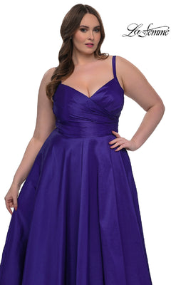 A woman models the La Femme 33075 long plus-size prom dress, featuring a sleeveless fitted bodice and flowing A-line skirt in deep purple, against a white background. "La Femme" is displayed in the top right corner.