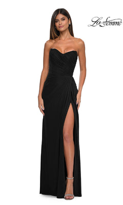 A woman poses confidently in front of a plain white background wearing the Classic Strapless Long Prom Dress: La Femme 33116 in black, featuring a sweetheart neckline and high thigh slit.
