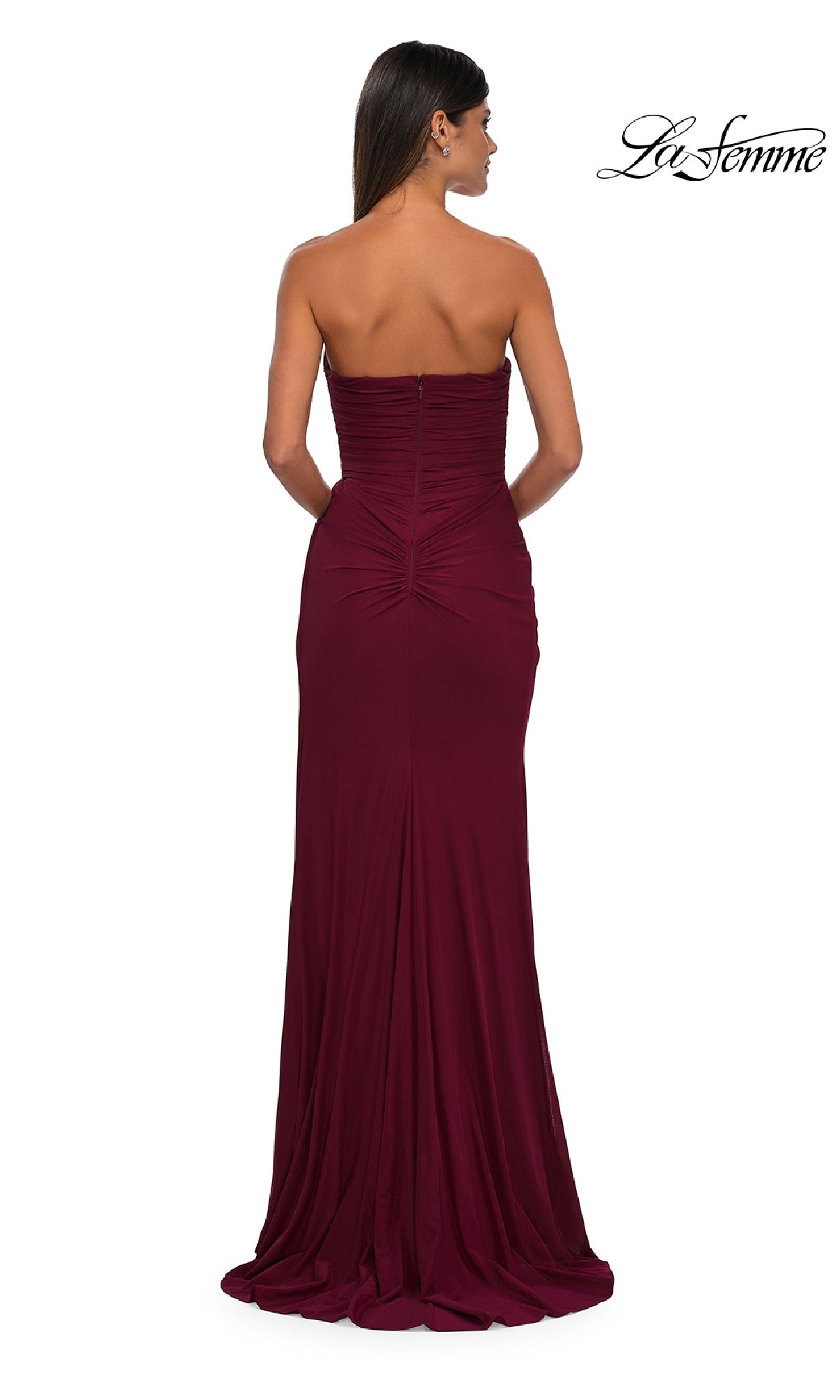 A woman faces away from the camera wearing the Classic Strapless Long Prom Dress: La Femme 33116, featuring a sweetheart neckline and ruching detail. The signature La Femme logo appears in the top right corner.