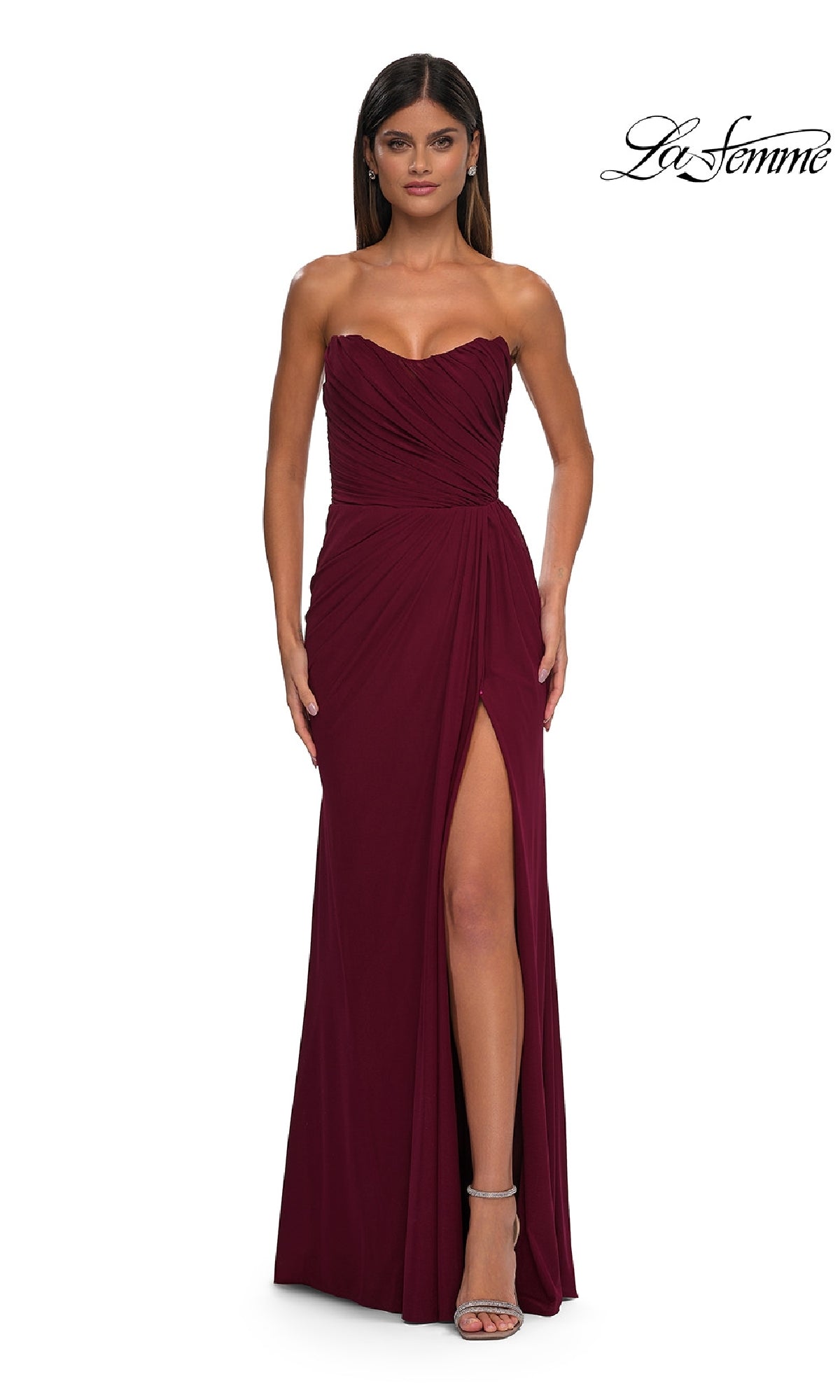 A woman in a dark berry La Femme 33116 classic strapless long prom dress with a sweetheart neckline and thigh-high slit stands facing forward, wearing silver heels. The La Femme logo appears at the top right.