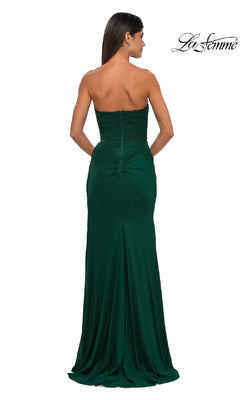 A woman faces away, showcasing the Classic Strapless Long Prom Dress: La Femme 33116 in dark green with ruching and a fitted back. The La Femme logo appears in the top right, emphasizing the gown's elegant design.