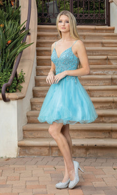 A young woman stands on stone steps in the Lace-Up-Back Short Babydoll Homecoming Dress 3315, featuring a beaded corset bodice, paired with sparkly high heels and lush green plants beside the stairs.