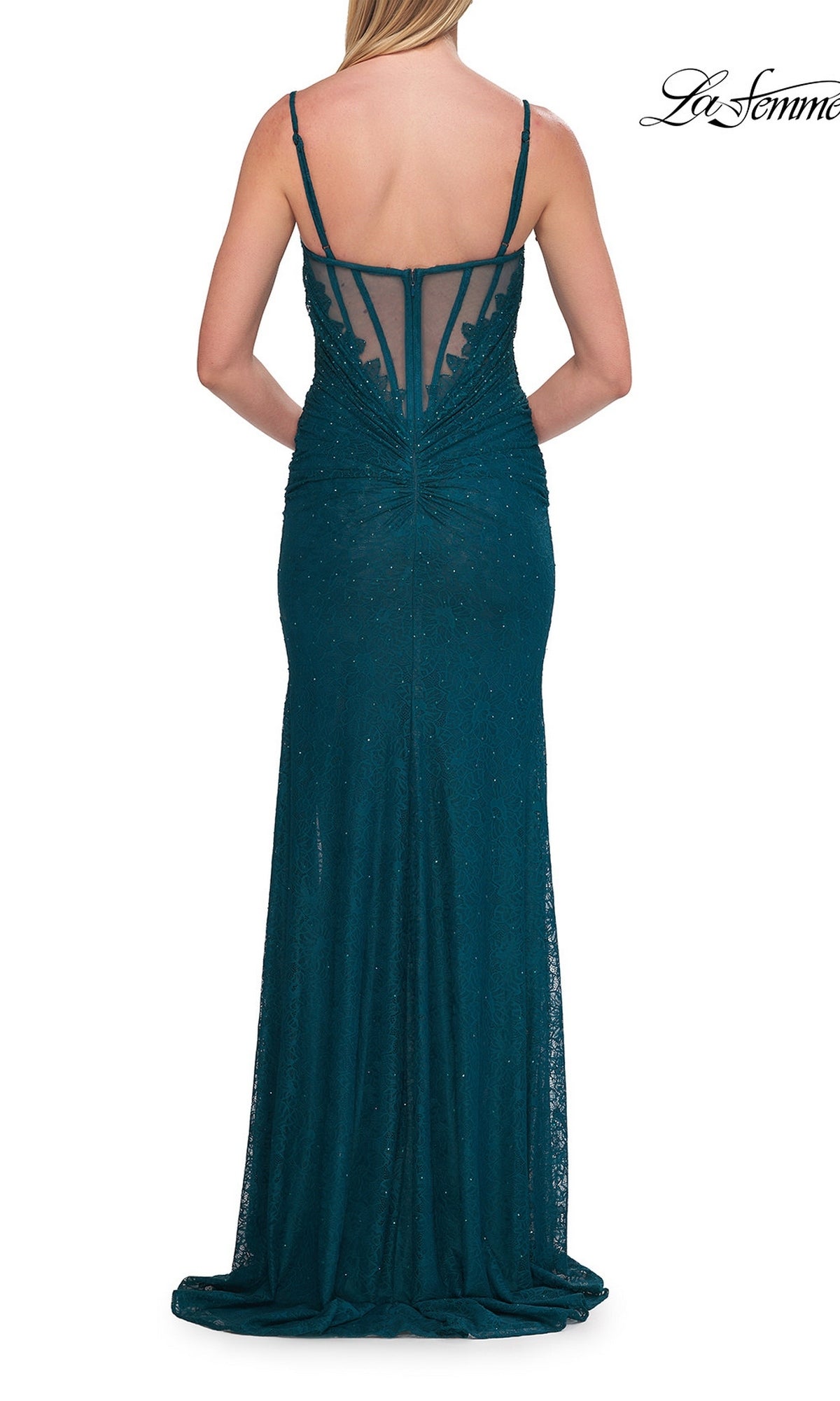 A woman is seen from behind, wearing the La Femme 33305 long prom dress—a floor-length dark teal gown with thin straps, a sheer back panel, subtle embellishments, and a structured corset bodice.
