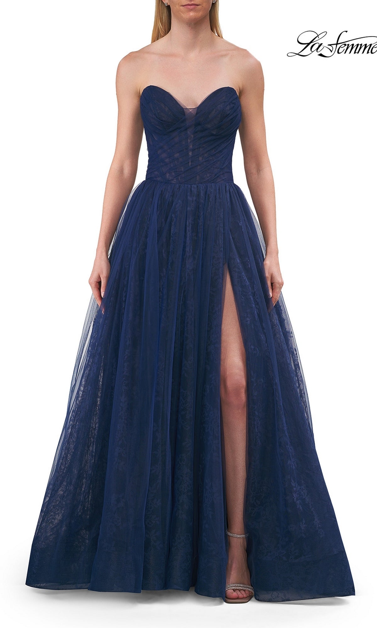 A woman stands with her hands at her sides, wearing the Long Prom Dress: La Femme 33307 in marine blue—a strapless, floor-length gown featuring a sweetheart neckline and high slit.
