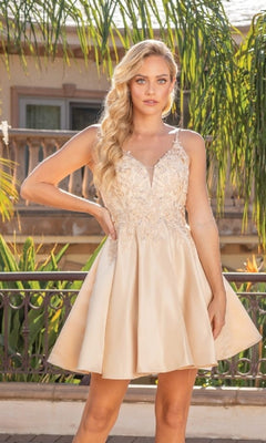 Woman wearing a short champagne dress with floral lace details in an outdoor setting.