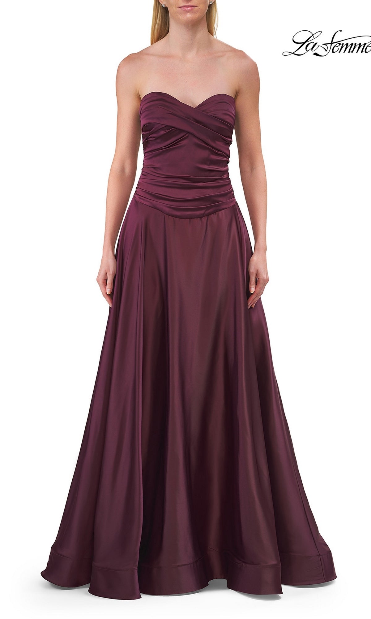 A woman wears the La Femme 33417 Strapless Sweetheart Prom Gown, a floor-length burgundy dress with a ruched bodice and flowing skirt.