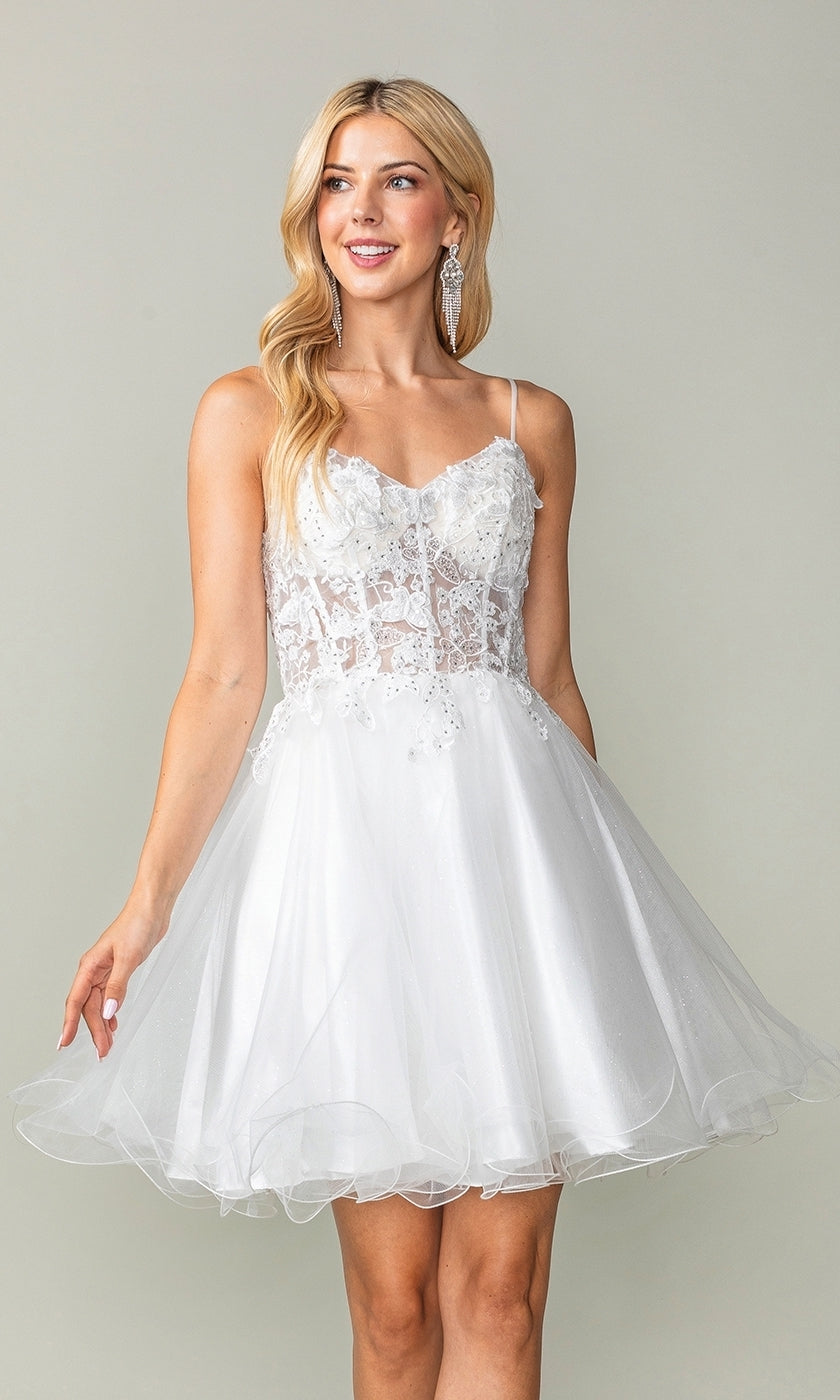 A woman models the Lace-Up Short Butterfly Homecoming Dress 3341, featuring a sheer lace bodice and flared tulle skirt, standing against a plain background.