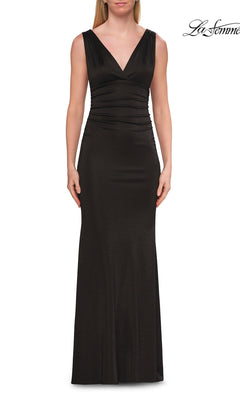A woman wearing the La Femme 33425 V-Neck Metallic Jersey Prom Dress in black, a sleeveless, floor-length gown featuring a V-neckline and ruched detailing at the waist, stands against a white background.