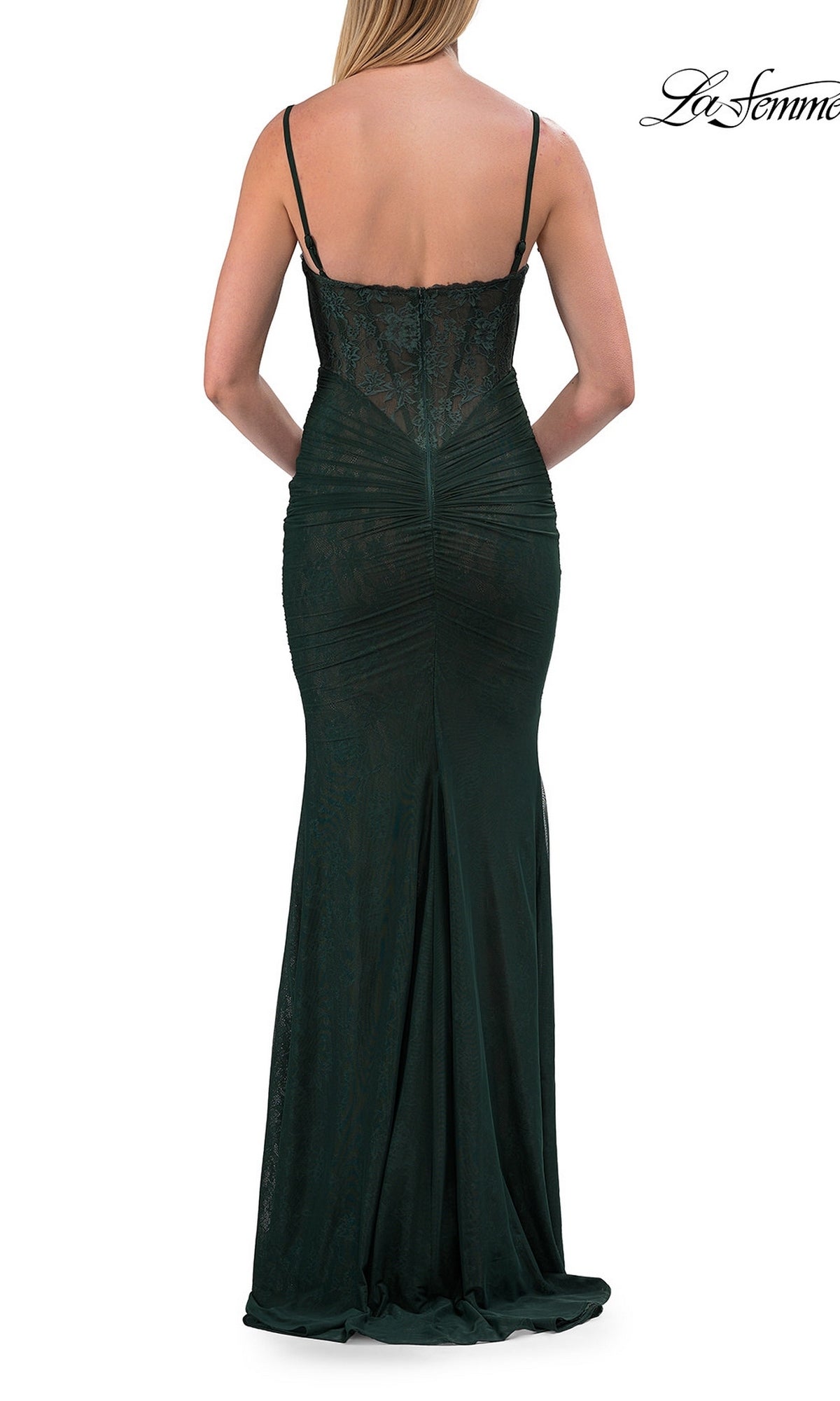 A woman is shown from the back wearing the Simple Long Lace Prom Dress: La Femme 33443, a dark green, floor-length formal gown featuring thin straps, a fitted silhouette, and an elegant v-neck design.