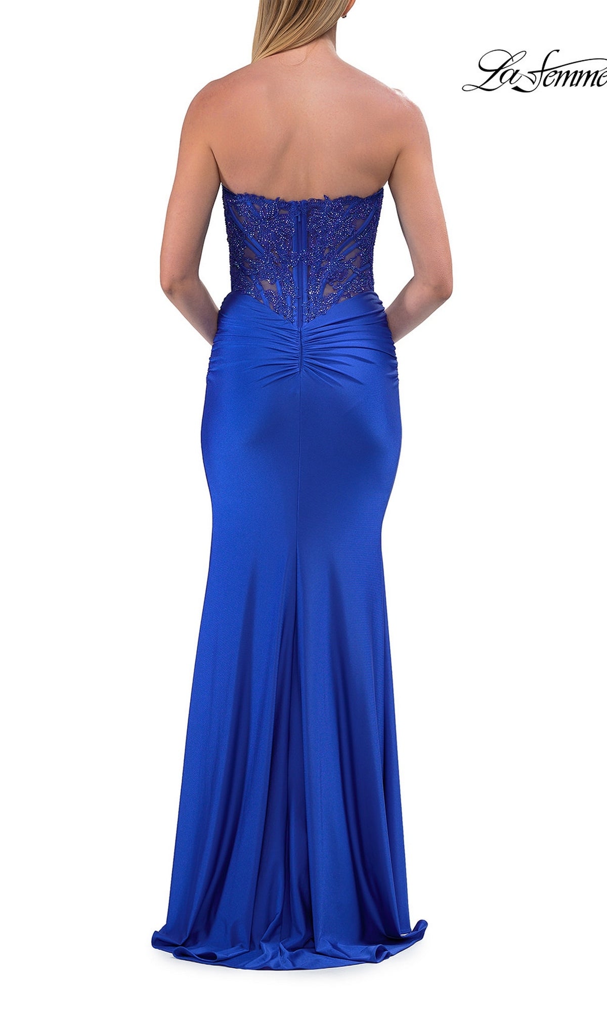 A woman is shown from the back wearing the La Femme 33509 Strapless Long Mermaid Prom Dress, a floor-length royal blue gown featuring a beaded-lace corset bodice and a fitted satin skirt.