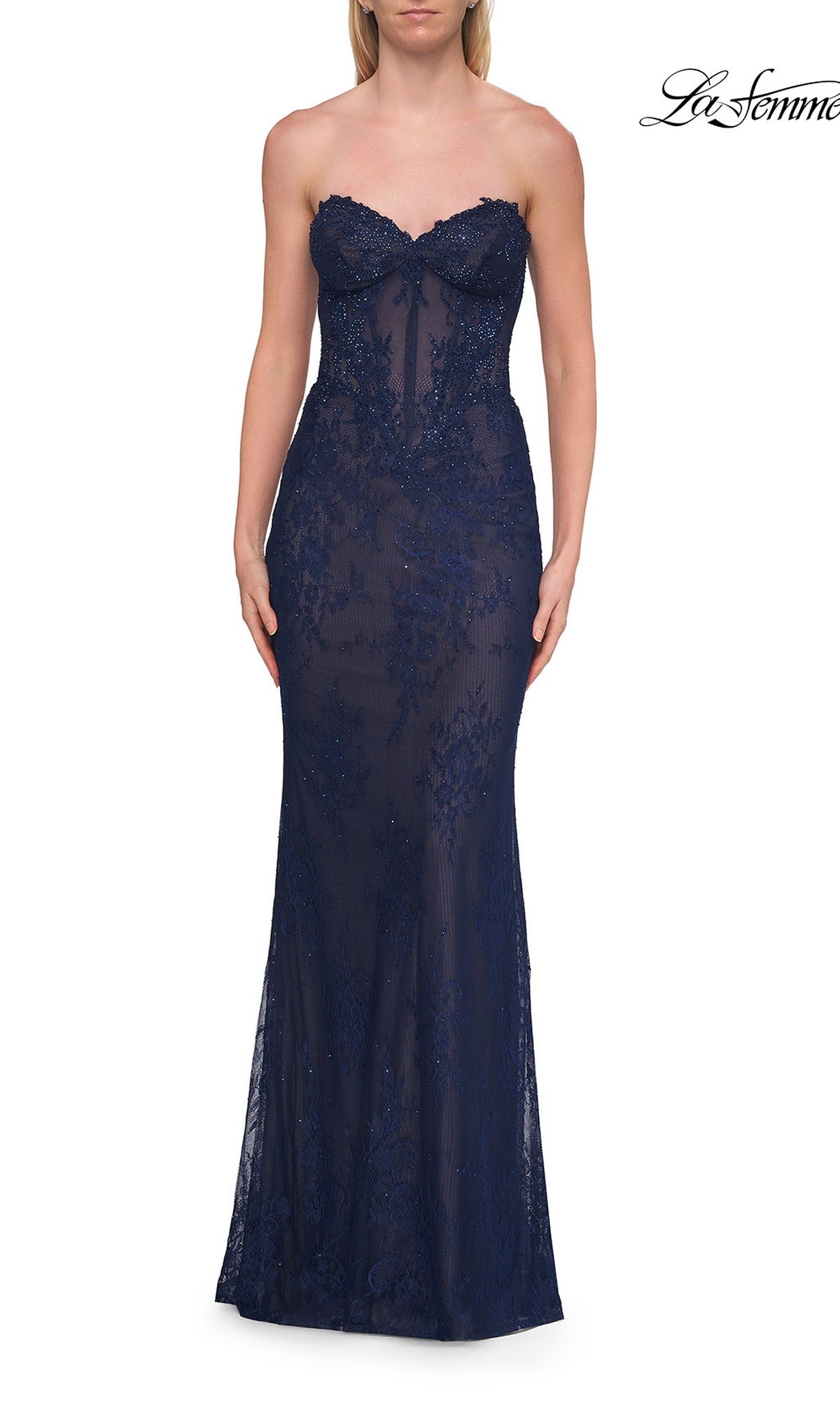 A woman wearing the Strapless Long Lace Prom Dress: La Femme 33518 in marine blue, featuring a strapless sweetheart neckline with sheer beaded floral lace and delicate beading details, fitted through the bodice and hips.