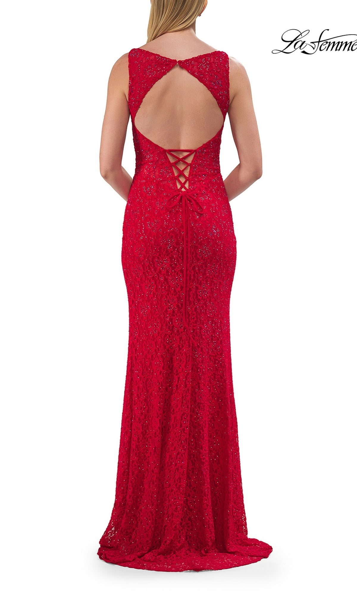 A woman stands facing away from the camera, wearing the La Femme 33519—a sleeveless red lace prom dress featuring an elegant lace-up open back and a floor-length hem.