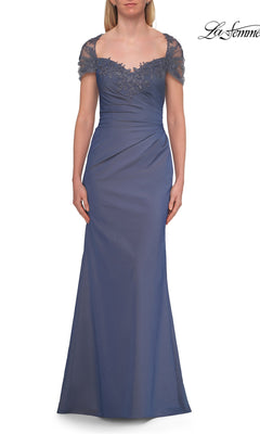 A woman wearing the La Femme 33579 Back Cut-Out Long Formal Dress in slate blue, featuring cap sleeves, lace accents on the neckline and sleeves, and gentle ruching at the waist—an elegant choice for a mother of the bride.