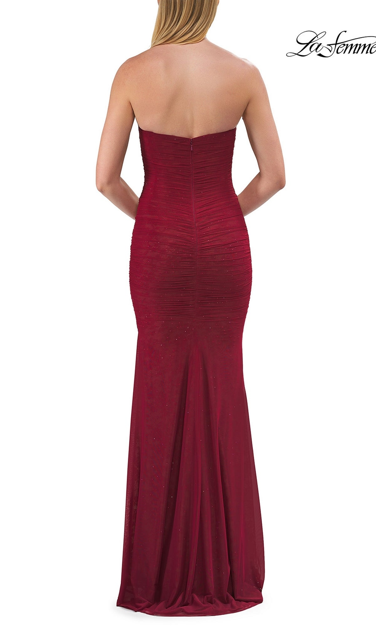A woman is elegantly photographed from the back wearing the La Femme 33601 Classic Strapless Long Prom Dress—a fitted red evening gown featuring slight ruching and a floor-length hem.