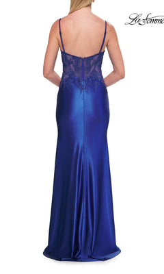 Woman wearing the La Femme 33627 beaded-corset long prom dress, featuring a sleeveless, floor-length royal blue design with lace detailing on the back, standing with her back to the camera.