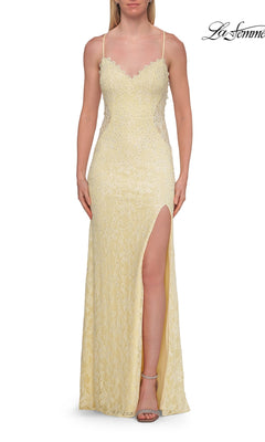 Wearing the Beaded Long Lace Prom Dress La Femme 33647 in pale yellow, a woman shows off its delicate lace, thin straps, strappy open-back design, high side slit, and subtle beaded embellishments.