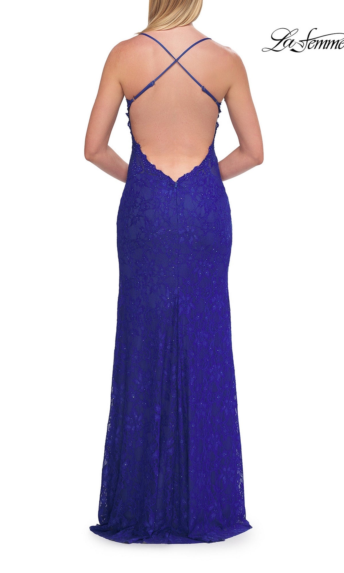 A woman stands facing away from the camera in the Beaded Long Lace Prom Dress: La Femme 33647, a floor-length, royal blue gown featuring delicate beaded lace, thin crisscross straps, and a low open back.