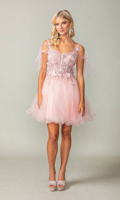 A woman stands against a plain light background wearing the Dancing Queen 3365 short homecoming dress in blush, featuring an off-shoulder neckline, lace details, and a glitter tulle skirt.