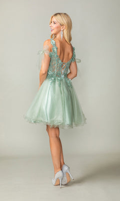 Wearing the Dancing Queen 3365 Short Homecoming Dress, a woman stands on a plain light background. The dress is a light green babydoll style with a lace-up back, sheer sleeves, delicate lace details, and a subtle glitter tulle skirt. She completes her look with gray high heels.