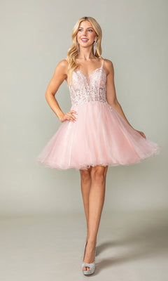 Woman wearing a pink dress with a lace top and tulle skirt on a plain background